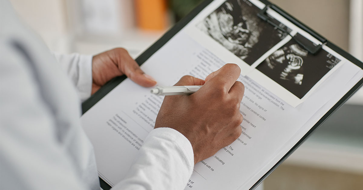 OBGYN physician reviewing maternity care documentation, representing 2027 CPT coding changes, reimbursement, and physician compensation
