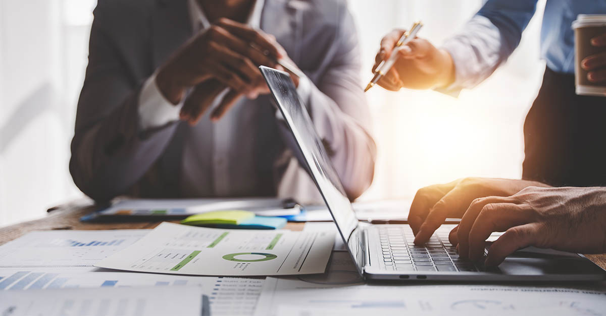 Clinical research professionals reviewing clinical trial budget negotiations and financial data