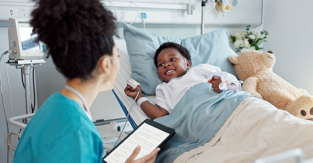 Healthcare professional caring for a child in a hospital bed, illustrating pediatric care and access to healthcare services at children's hospitals.